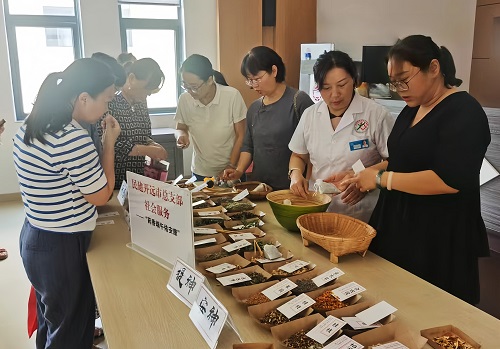 图为：民建开远市总支部会员与社区居民互动学习中药香囊制作.jpg